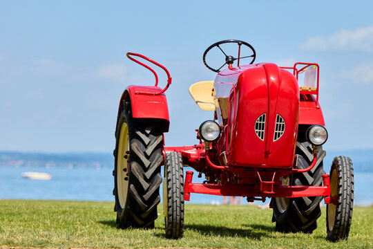Klassischer roter Oldtimer-Traktor auf der Wiese