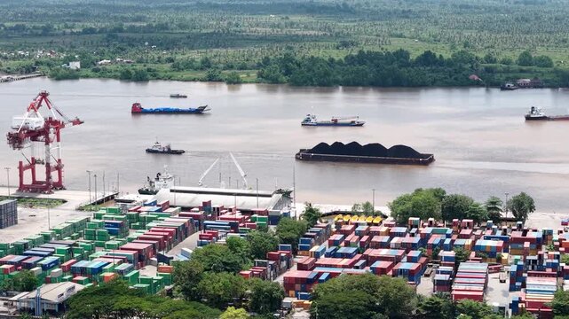 Aerial view of tugboats pulling coal-laden barges near the port