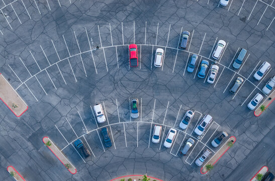 Aerial view of parked cars in a curved asphalt parking lot with white lines and tire marks Summerlin South, Nevada, United States.