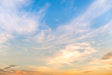 Naklejka premium Sky sunset,Beautiful sunrise sky with vibrant gradient orange and gold colors and soft blue, Clear atmosphere with wispy clouds. Peaceful, perfect for background and copy space, High resolution images