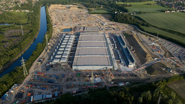 Aerial view of the Charleroi SAM 3A data center construction site with industrial machinery and a nearby canal Farciennes, Region wallonne, Belgium.