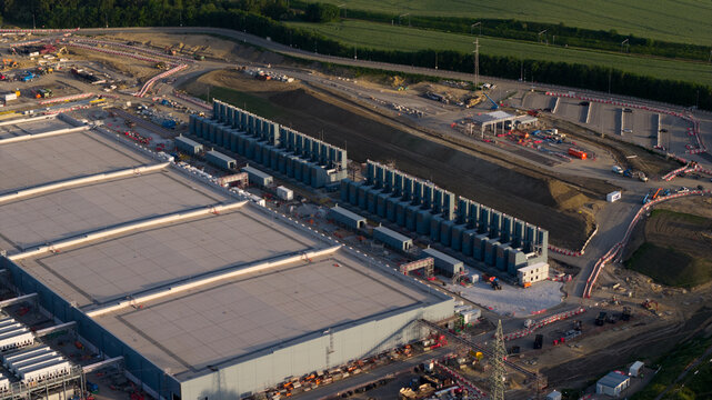 Aerial view of the Charleroi SAM 3A data center construction site with industrial buildings and cooling units in Farciennes, Region wallonne, Belgium.