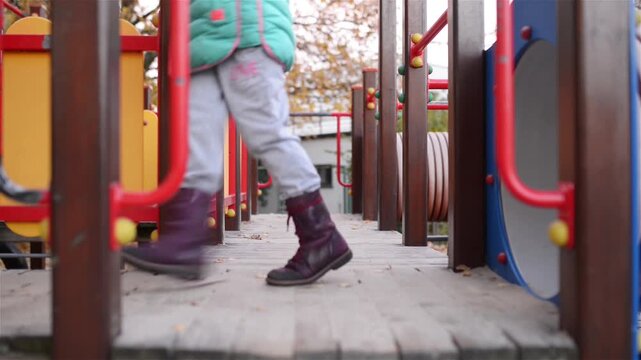 Two little beautiful girls walk on playground