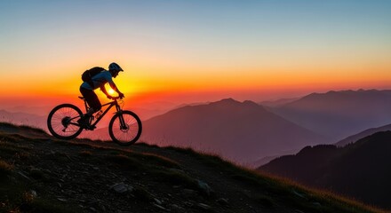 Fototapeta premium Silhouette of a Mountain Biker Riding on a High Alpine Ridge at Sunset with Majestic Mountain Peaks in the Background