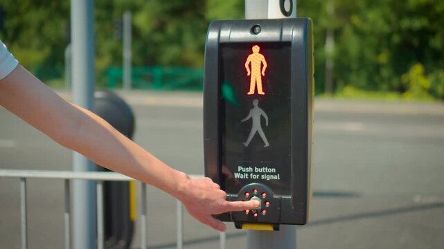 Green pedestrian traffic light allowing road crossing after signal button activation. Woman crossing street after walk sign appearing on urban intersection control system. Public transport safety and