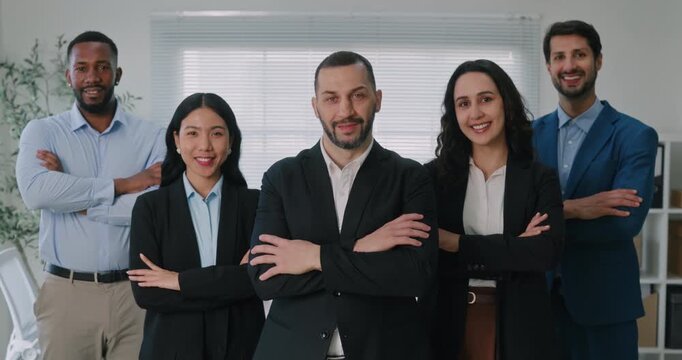 Portrait of diverse business experts team stands with arms crossed in office. Multiethnic entrepreneurs group performs cooperation spirit at company workplace