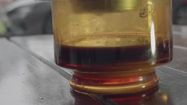 Close-up of coffee dripping from Vietnamese phin filter into glass