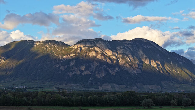 Aerial view of the rugged limestone cliffs and forested slopes of the mountain range overlooking the valley floor in Barraux, Auvergne-Rhone-Alpes, France.