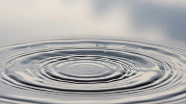 Captivating Water Drop Impact - Creating Ripples and Splashes in Tranquil Liquid Surface.