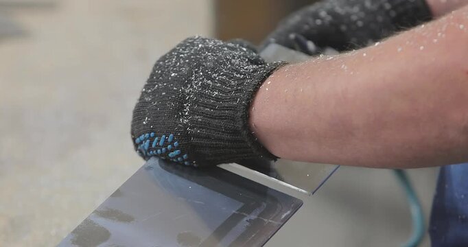 A worker processes an aluminum plate with a pneumatic grinder. Remove Sharp Edges and Burrs from Metal Parts. Carbide bur provides increased metal removal rates. Close-up