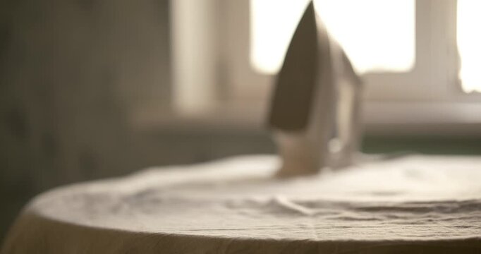 ousehold chore of ironing into a visually stunning piece of art. The scene captures a delicate white garment, possibly a blouse or lingerie with intricate lace detailing, resting on an ironing board. 