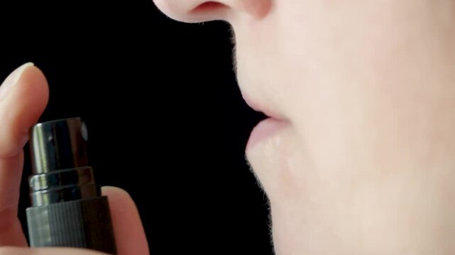Woman using oral spray for healthcare and wellness routine