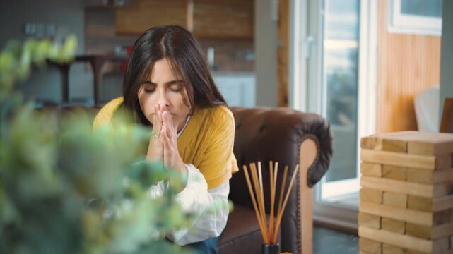 Video of a young Hispanic woman sitting on the sofa at home with a feeling of frustration and negative emotion.
