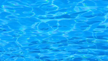 Obraz premium Bright Blue Swimming Pool Water Surface with Ripples and Sun Reflections