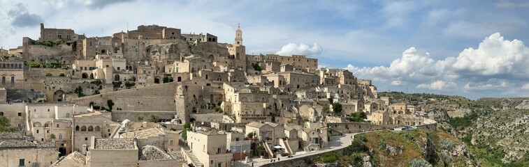 Naklejka premium Historic stone hillside town Matera under dramatic cloudy sky, Basilicata, Italy, May 2025