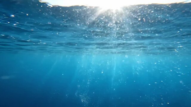 Clear underwater ocean scene with sunlight streaming through surface