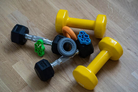 Colorful dumbbells and fitness equipment on wooden floor