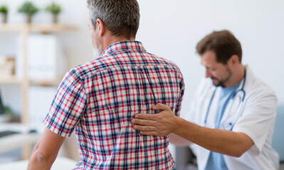 Fototapeta premium Orthopedic doctor examining chronic back pain patient in clinic