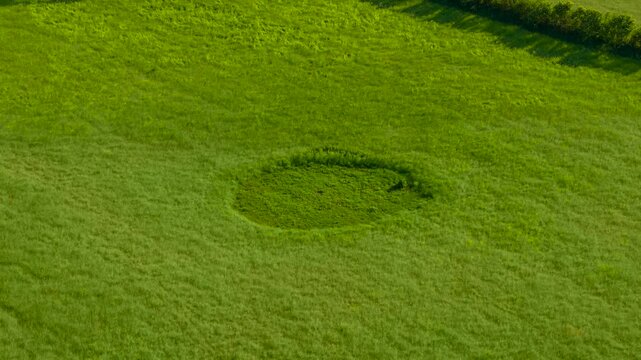 Mysterious crop circle emerging in green field. Aerial rural landscape evoking alien presence paranormal phenomenon and world mysteries. Enigmatic circular pattern inspiring UFO theories conspiracy