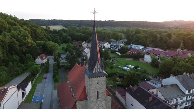 Aerial drone orbit shot of a beautiful historic church in a small european town at sunset, cinematic architecture footage