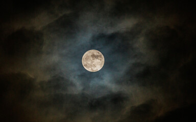 Sharp details of craters on the illuminated full moon during a clear starry night sky background. © Wanchai