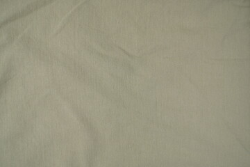 Obraz premium Close-up texture of olive green cotton fabric. Detailed textile material with subtle creases, ideal for apparel, military-style fashion, or neutral background concepts.
