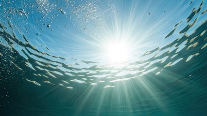 Obraz premium Sunlight rays through blue ocean water surface.