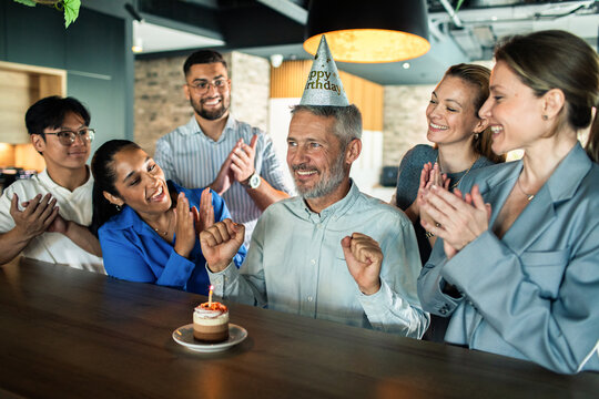 Coworkers celebrating a man's birthday at the office