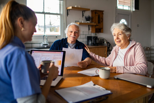 Senior couple meeting with home nurse in kitchen