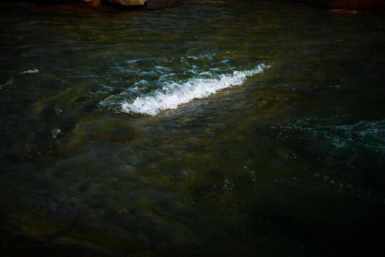 A standing wave in the rapids of shallow moving water