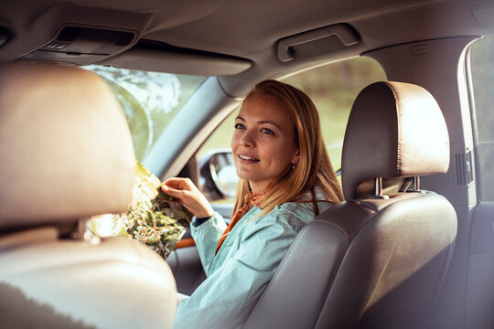 Young woman reading road map in car interior