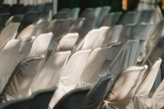 Rows of neat, patterned white chairs covered in clean cloth