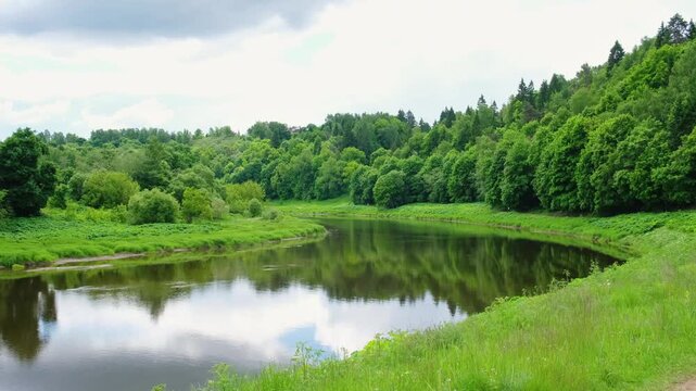 River landscape with green forest and cloudy sky, peaceful nature scenery, illustrating natural landscape beauty, environmental conservation and peaceful outdoor scenery for nature appreciation