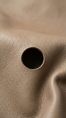 Fototapeta premium Closeup of a hole in a textured beige surface.