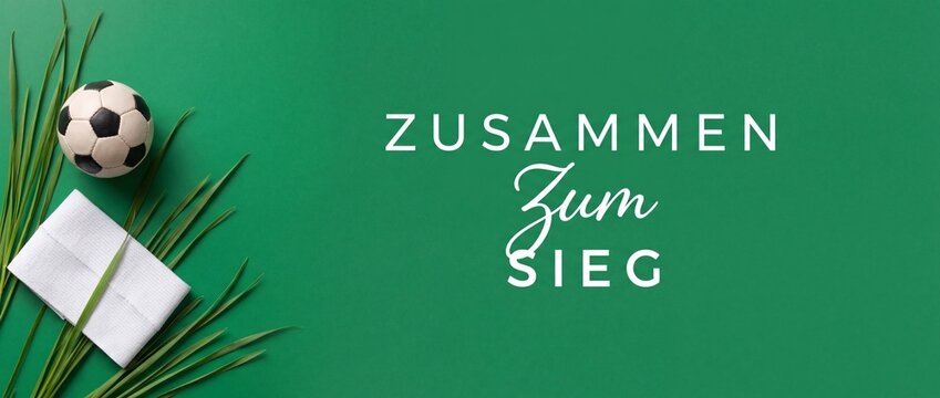 German soccer team motivation concept with a mini football ball, wrist sweatband, and green grass palm leaf on solid background, featuring teamwork slogan text Zusammen Zum Sieg for victory.