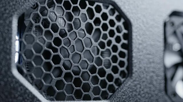 Close up of a dark grey hexagonal computer fan grill