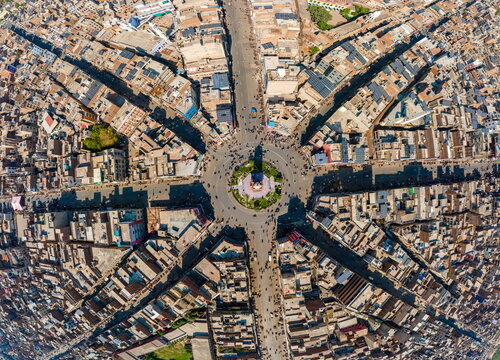 Aerial view of the Clock Tower Faisalabad and its iconic eight radiating streets surrounded by dense urban architecture and rooftops in Faisalabad, Punjab, Pakistan.