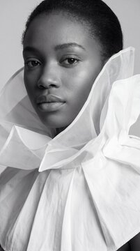 Extreme close-up monochrome high fashion editorial portrait of woman with sheer ruffled collar for magazine cover and beauty background