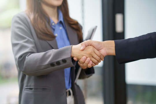 Business partners shaking hands, concluding an agreement or job interview. Concept of successful teamwork, collaboration, and trust