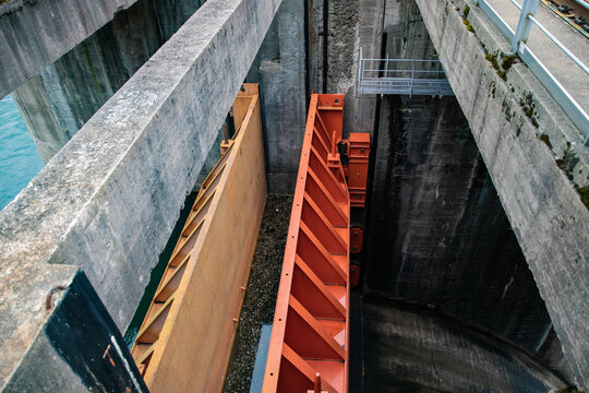 Concrete hydropower dam spillway with steel floodgate and maintenance walkway