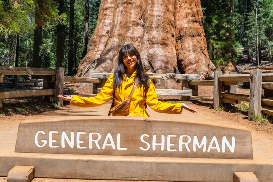 Woman posing with general sherman tree sign in sequoia national park