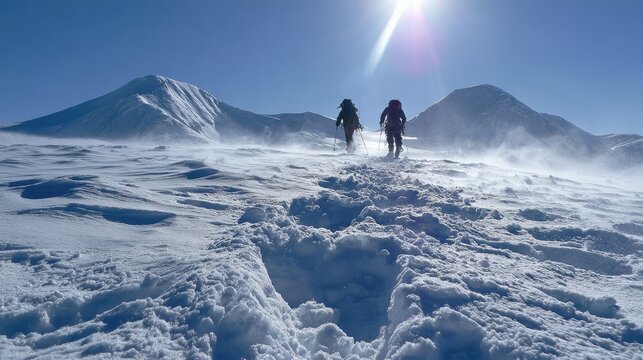Two figures ascend a snow-covered mountain under a bright, sunlit sky