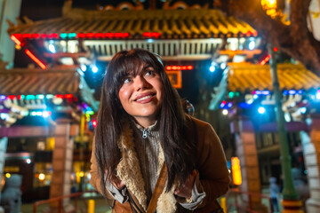 Fototapeta premium Woman exploring chinatown dragon gate in san francisco at night