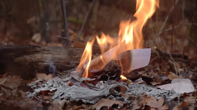 Closeup of woman saying goodbye to past memories and burning her diary Hand feeding letters into flames as symbolic act of letting go and privacy protection
