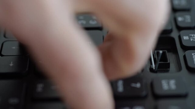 Closeup laptop keyboard missing keycaps showing finger prying metal clip, exposed scissor mechanism, jagged plastic fragments, quick repair attempt by home user, tense intimate