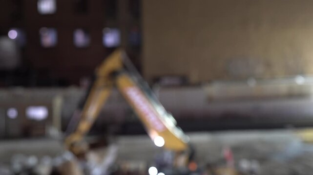 A cinematic nighttime video clip of an industrial drilling machine at a construction site.
