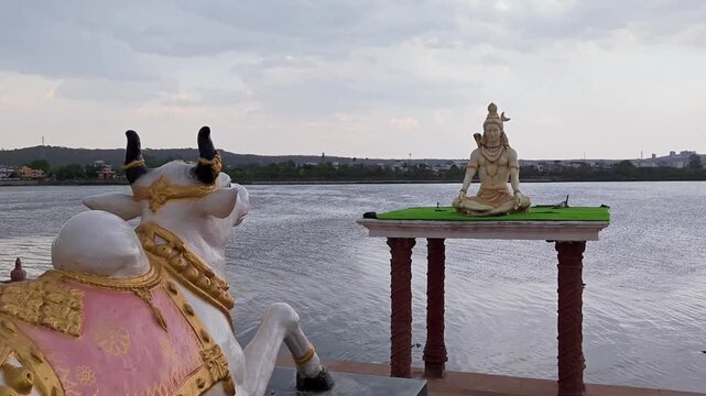 Closeup of lord shiva statue with flowing river background