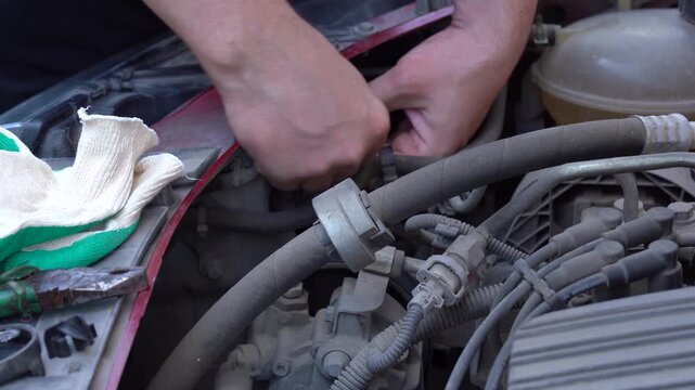 Hands Engaged in Automotive Maintenance: Repairing a Vehicle's Engine and Components with Tools in a Close-Up View