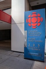 Naklejka premium Toronto, Ontario, Canada - June 19, 2018: A signage for Canadian Broadcasting Corporation at one of the entrances to the headquarters on Wellington Street West in Toronto, Ontario, Canada. 