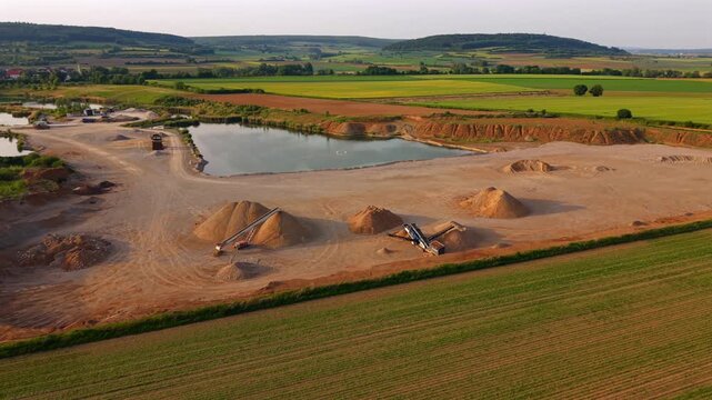Elevated drone perspective of a gravel factory and quarry site showing material processing, earthmoving activities and aggregate resources for concrete production